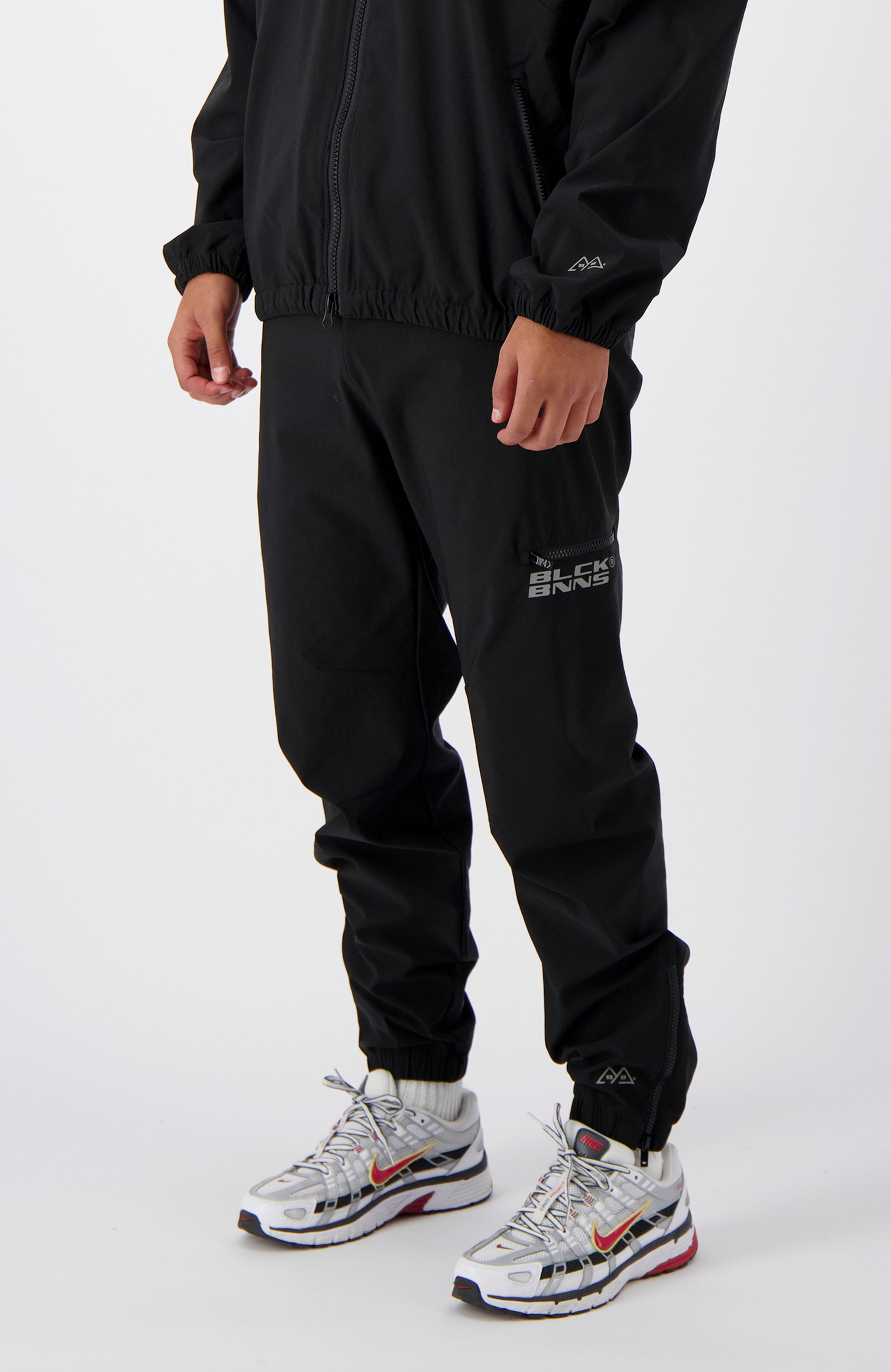 //blackbananas.com/cdn/shop/files/INITIAL_TRACKPANTS_1.224.4.04-000000-bottom-10_{width}x.jpg?v=1726585137